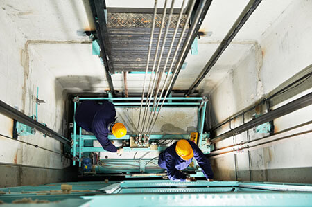 construction workers in open elevator shaft