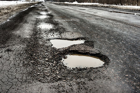 Road with potholes, dangerous roadway lawyers